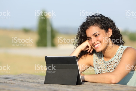 Girl watching video on a tablet outdoors